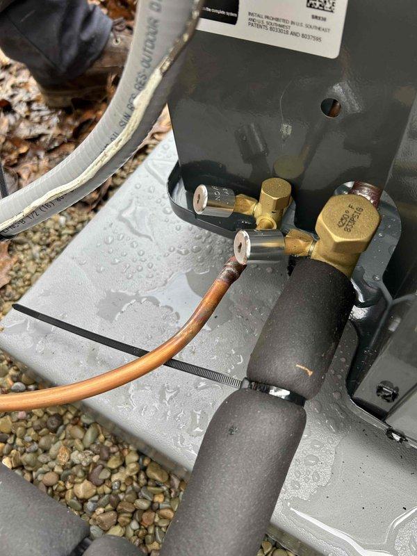 Completed installation of a new 80% efficient furnace, air conditioning system, and 50-gallon hot water tank in customer's basement utility area. System includes properly insulated copper refrigerant lines connected to the outdoor condensing unit with brass valve assembly, and new metal ductwork installed along the ceiling. All components were tested, properly secured, and confirmed operational before completion.