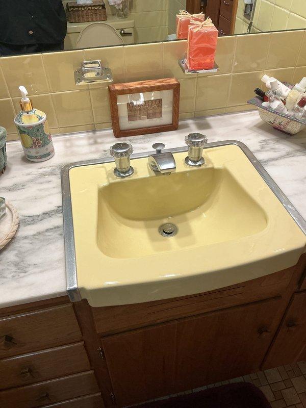 Conducted comprehensive plumbing inspection of bathroom vanity with chrome fixtures and basement utility area. Documented condition of sink plumbing components and surrounding cabinetry. No active leaks or functional issues identified during the inspection.