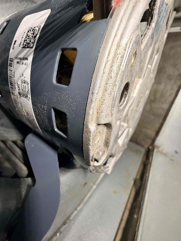 Performed scheduled heating maintenance on aging system (10+ years old). Inspected blower motor assembly which showed signs of normal wear, including dusty components and slight corrosion on mounting bracket. All electrical connections to motor remain intact with proper wire routing through ventilation housing.