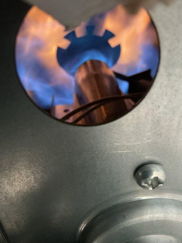 Performed scheduled heating maintenance on system. Conducted electrical amperage testing on components with clamp meter showing readings within normal parameters (0.3A). Inspected gas burner assembly and verified proper flame pattern with characteristic blue center/orange tips, indicating optimal fuel-air mixture and complete combustion.