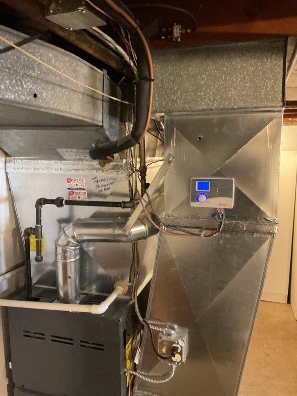 Performed routine heating system maintenance on a residential furnace unit with connected ductwork and ventilation components. Inspected control panel functionality, gas line connections, and overall system operation. All components found to be in proper working order with no issues identified.