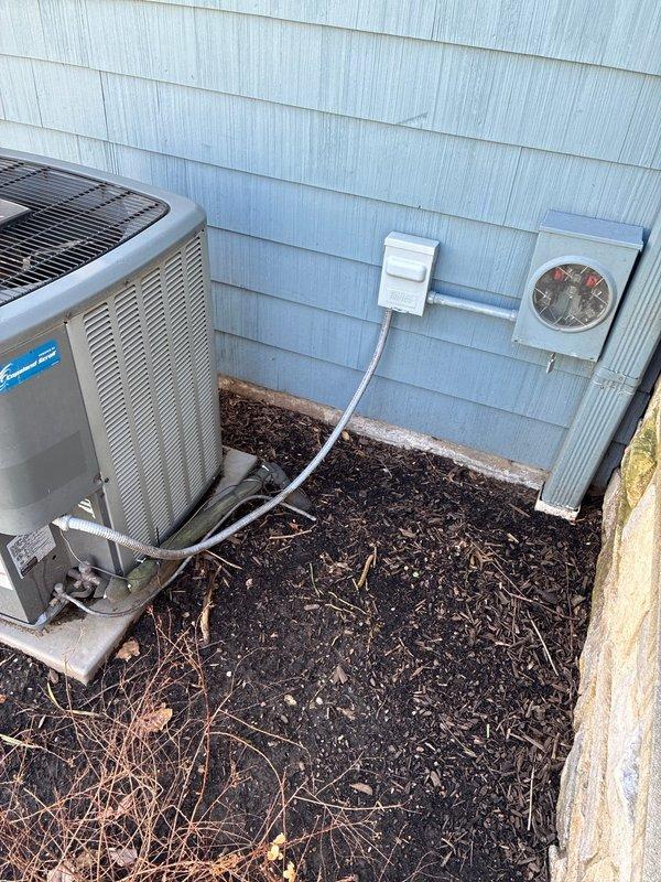 Conducted assessment of 18-year-old HVAC system at slab home with easy access. Inspected existing outdoor AC unit mounted on concrete pad with electrical disconnect box and meter. Examined thermostat wiring and connections, noting system age and customer's report of insufficient heating during winter months. Provided replacement options for both furnace and complete system.