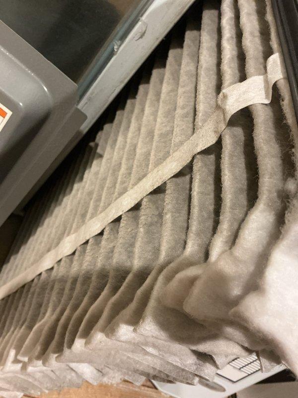 Performed scheduled heating maintenance on furnace system. Inspected and evaluated air filter condition, noting moderate dust accumulation on pleated filter. Conducted electrical testing with multimeter on system components to verify proper voltage and connections across colored wiring terminals.