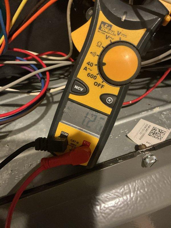 Performed scheduled heating maintenance on furnace system. Inspected and evaluated air filter condition, noting moderate dust accumulation on pleated filter. Conducted electrical testing with multimeter on system components to verify proper voltage and connections across colored wiring terminals.