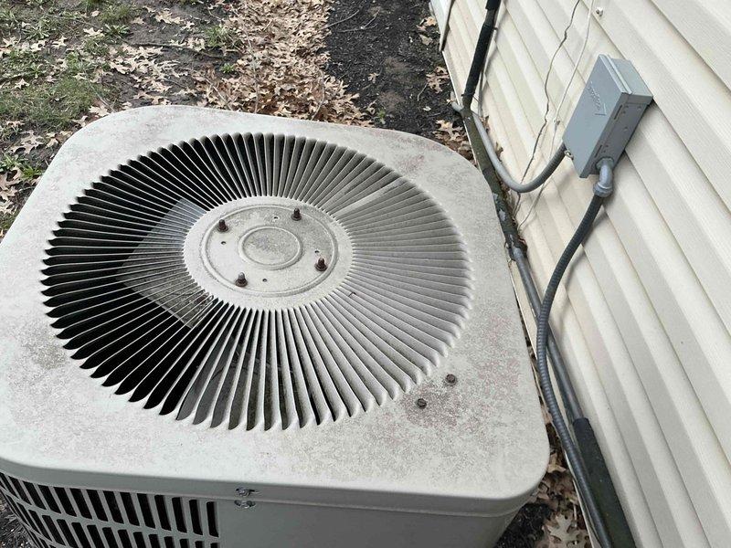 Conducted full system inspection of existing forced air HVAC equipment including outdoor AC condenser unit showing signs of weathering and environmental exposure. Evaluated current ductwork configuration and drainage system consisting of PVC piping and metal hanging hardware in utility area. Presented replacement options for complete HVAC system and hot water tank to improve efficiency and reliability.