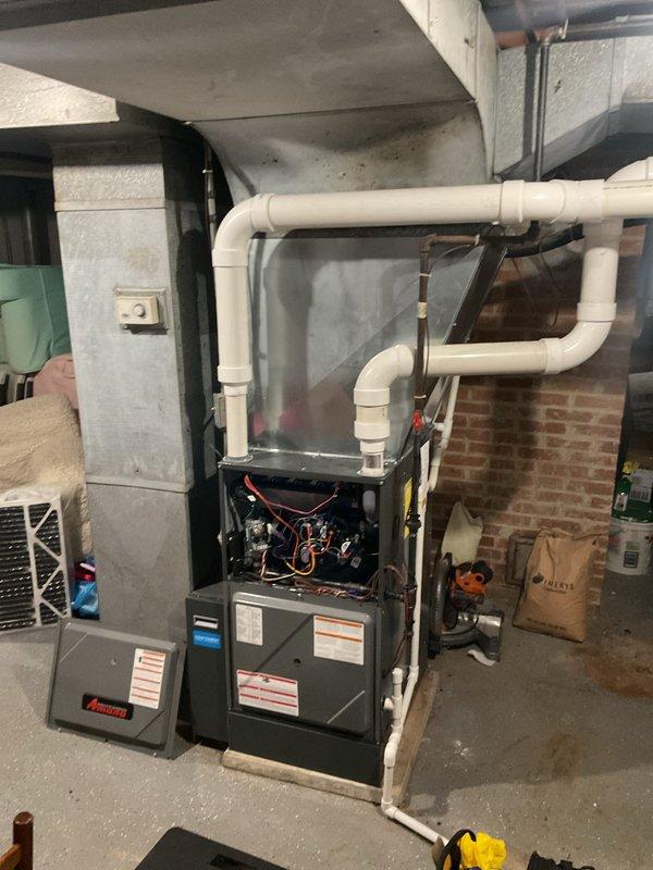 Performed routine heating maintenance on residential furnace system. Inspected internal electronic components and wiring with access panel open, and verified proper installation of PVC exhaust/intake piping. Checked connected humidifier mounted to ductwork and examined copper line connections to ensure system functionality.