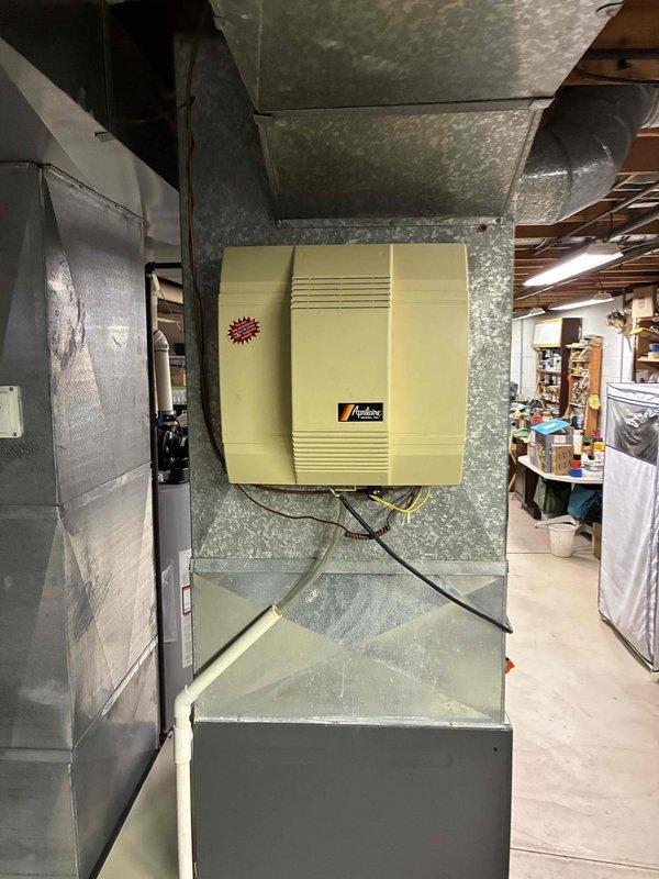 Performed scheduled heating maintenance service on customer's furnace system. Inspected heat exchanger and fins for proper operation, finding minimal dust accumulation and normal working condition. Examined the Aprilaire humidifier mounted on ductwork, verifying proper installation and connections to ensure optimal system performance during heating season.