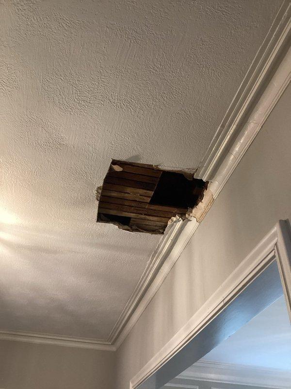 Responded to emergency water leak call where customer reported water leaking through first floor ceiling. Upon inspection, identified significant ceiling damage with exposed wooden structural elements. Investigated source of leak despite no bathroom directly above affected area, determined cause, and completed necessary repairs to prevent further water damage to ceiling and crown molding.