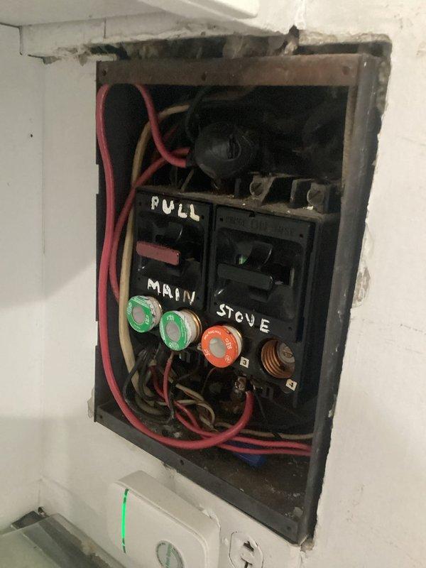 Conducted site assessment of century-old home's original electrical panel system. Documented severely outdated fuse box with handwritten circuit labels ("PULL," "MAIN," "STOVE") and deteriorated mounting conditions. Provided comprehensive replacement quote for upgrading to modern circuit breaker panel that will meet current electrical code requirements.