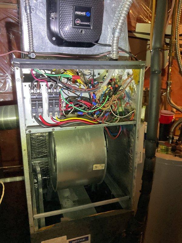 Responded to customer complaint of loud noise from furnace. Upon inspection, accessed interior components including blower assembly and control panel. Identified and serviced the blower wheel/fan assembly which showed dust accumulation, resolving the noise issue.