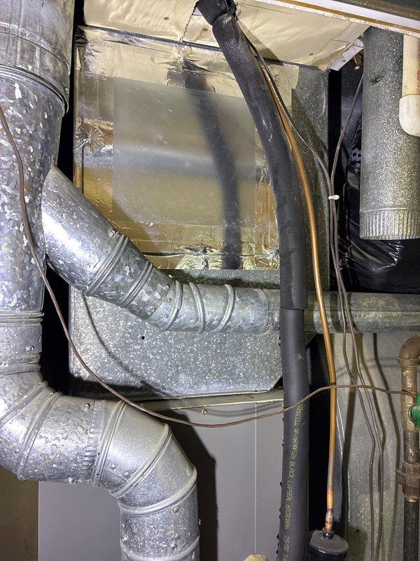 Conducted assessment of 30-year-old first floor furnace system for replacement options through insurance claim. Inspected existing installation including aged furnace unit, connected galvanized sheet metal ductwork, and associated refrigerant lines. Documented current system configuration including insulated piping, drainage components, and electrical connections to determine appropriate replacement specifications.