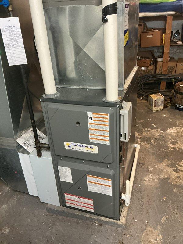 Performed scheduled maintenance on residential HVAC heating system with AirScrubber air purification device. Inspected furnace unit with dual PVC ventilation pipes for proper operation and airflow. System functioning normally with no issues identified; equipment appears to be in good working condition with all safety features operational.