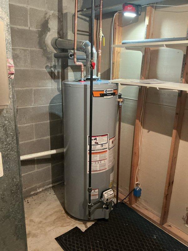 Successfully replaced an aging atmospheric gas water heater with a new 50-gallon State model. Installation included proper connection of copper supply lines with shutoff valves, PVC venting, and placement on a protective rubber mat in accordance with manufacturer specifications. All connections were pressure tested to ensure leak-free operation and proper function.