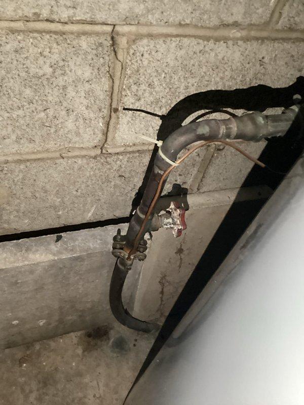 Conducted comprehensive plumbing inspection of copper supply lines and associated fittings in utility area. Documented existing installation showing signs of oxidation at connection points and examined insulated mechanical components along concrete block wall. Photographed all components for documentation purposes with special attention to pipe junctions and previous repair work.