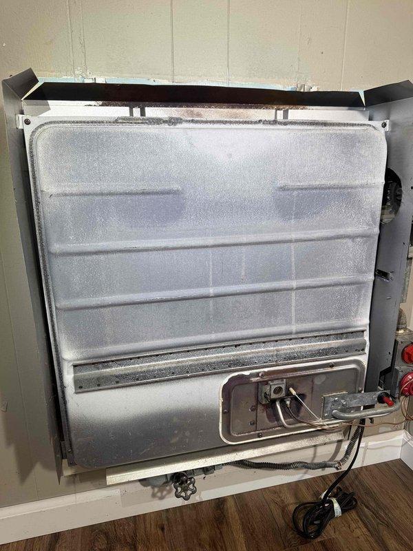 Diagnosed wall furnace with no heat issue. Removed front panel to access internal components, finding frost buildup on heat exchanger indicating possible refrigerant flow restriction. Cleared frost, checked electrical connections, and restored proper operation of the heating system.