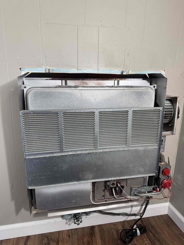 Diagnosed wall furnace with no heat issue. Removed front panel to access internal components, finding frost buildup on heat exchanger indicating possible refrigerant flow restriction. Cleared frost, checked electrical connections, and restored proper operation of the heating system.