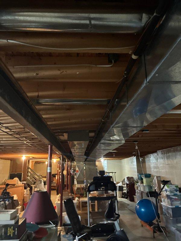 Conducted comprehensive assessment of 30-year-old forced air HVAC system in basement. Inspection revealed aging ductwork with visible metal channels running through exposed ceiling joists. System has reached end of useful life and replacement is recommended based on age and condition of equipment.