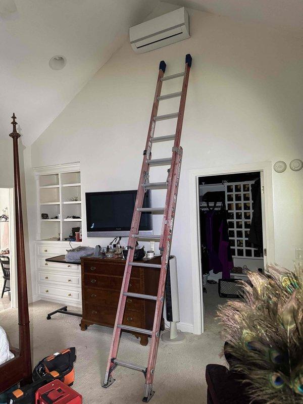 Performed comprehensive maintenance on residential heating system. Conducted electrical testing with multimeter showing 231V reading at unit terminals. Accessed ceiling-mounted air handler using extension ladder and inspected internal components including wiring connections and PVC condensate lines.