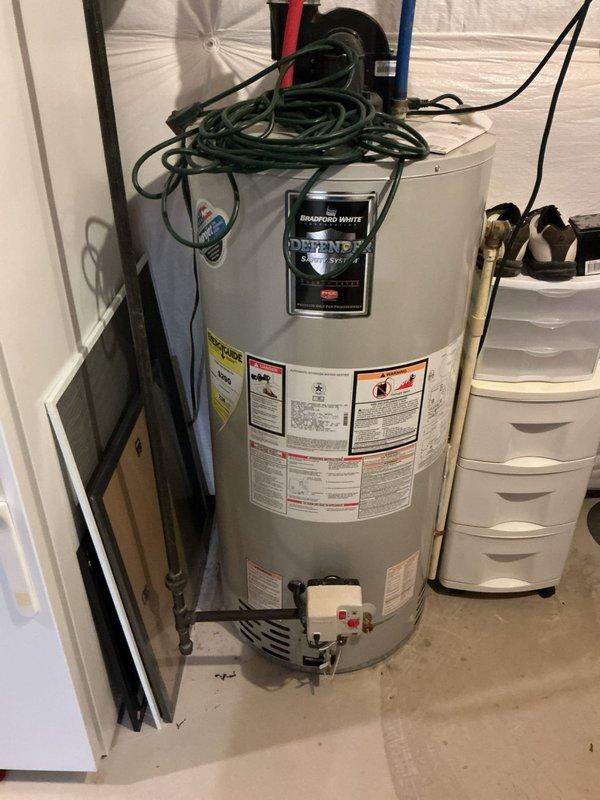Conducted an on-site evaluation of existing Bradford White Defender water heater installation. Unit shows signs of aging with proper hot/cold water connections and ventilation system. Documented current installation configuration including plumbing connections, electrical components, and surrounding utility area. Prepared estimate for replacement water heater with comparable specifications.