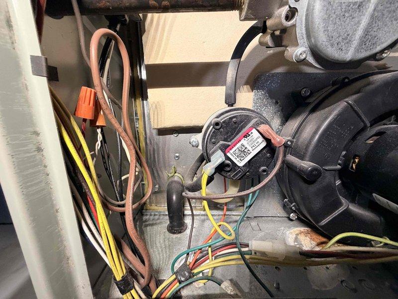 Performed routine heating system maintenance and inspected customer's expansion tank. Examined motor assembly and electrical connections, noting normal dust accumulation. Inspected pressure switch, associated wiring, and blower assembly components. All components functioning properly with no issues identified in the expansion tank at this time.