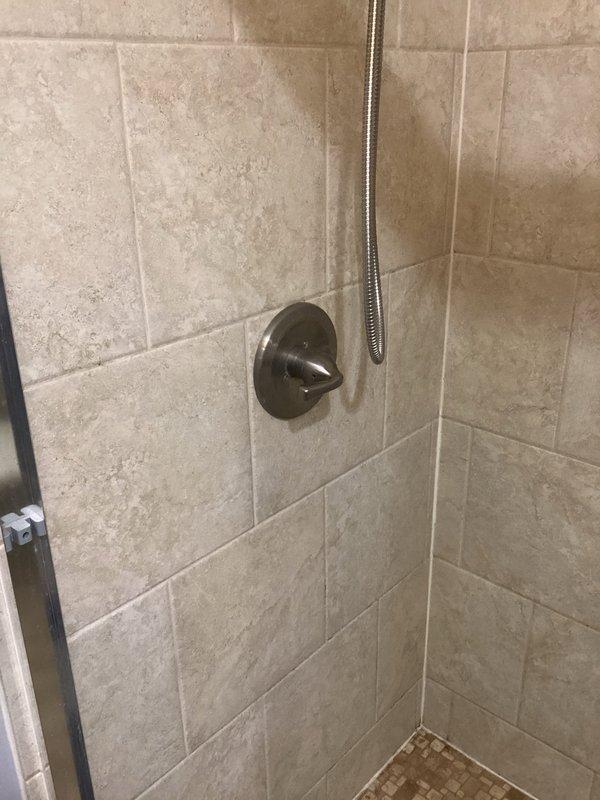Conducted comprehensive plumbing inspection of bathroom fixtures. Examined shower stall with brushed nickel control valve and flexible hose, noting condition of tile surfaces and grout lines. Inspected toilet functionality, observing standard tank mechanism and checking for proper water flow and potential leakage issues.
