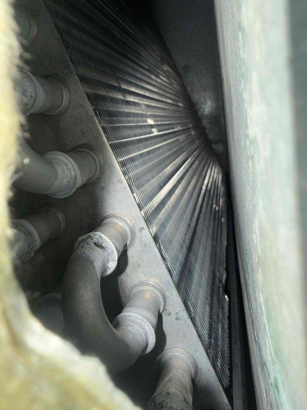 Performed routine heating system maintenance inspection with focus on the heat exchanger and evaporator coil assembly. Visual examination revealed heat transfer fins and copper tubing in satisfactory condition with minor dust accumulation. Documented system condition with detailed photos of internal components for maintenance records.
