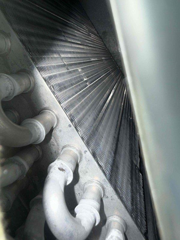 Performed routine heating system maintenance inspection with focus on the heat exchanger and evaporator coil assembly. Visual examination revealed heat transfer fins and copper tubing in satisfactory condition with minor dust accumulation. Documented system condition with detailed photos of internal components for maintenance records.