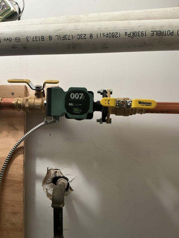 Conducted electrical inspection of residential plumbing system, documenting copper pipe installation with valve assemblies and a digital flow meter. Observed proper installation of shut-off valves and identified potential wall penetration issues requiring attention.