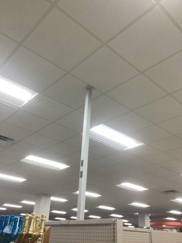 Conducted site assessment for potential electrical rewiring project in a commercial retail space, examining the existing electrical infrastructure serving the drop ceiling fluorescent lighting system and HVAC control mechanisms. Documented current wiring conditions and identified potential upgrade requirements for the ventilation system's control components and lighting fixtures.