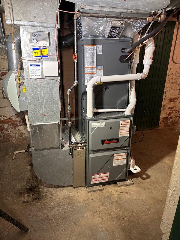 Successfully installed complete Amana HVAC system including 96% efficiency furnace, AC unit, and water panel. System includes properly connected PVC venting, copper lines, and all required control wiring with exterior condenser placed on concrete pad.
