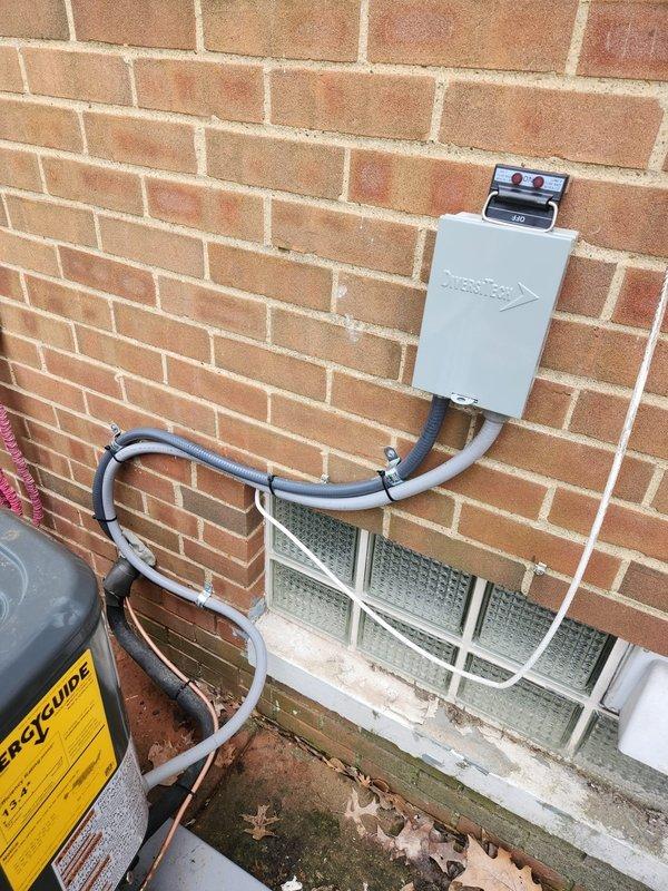 Completed installation of new outdoor A/C unit on concrete pad adjacent to brick exterior wall. System installation included proper mounting of disconnect box, running of copper refrigerant lines with insulation, and connection of all necessary electrical components. All service valves were properly installed and system was verified operational with appropriate line set routing and electrical connections completed according to manufacturer specifications.