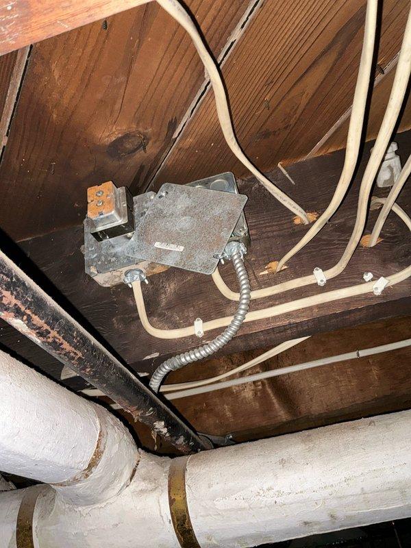 Performed assessment of leaking boiler system in utility area. Unit shows signs of water leakage requiring repair. Documented existing installation including blue heating unit with copper supply lines, electrical connections, and associated plumbing to provide client with repair options.