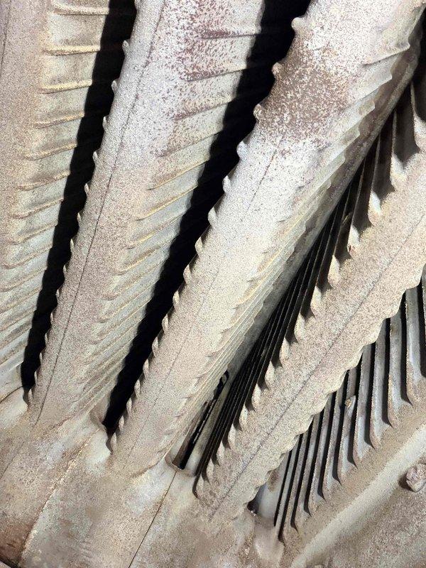 Performed routine maintenance on boiler system. Inspected heat exchanger fins, noting minor rust formation and debris accumulation. Examined concrete housing structure with particular attention to ventilation channels, which showed normal weathering but remain functionally sound.