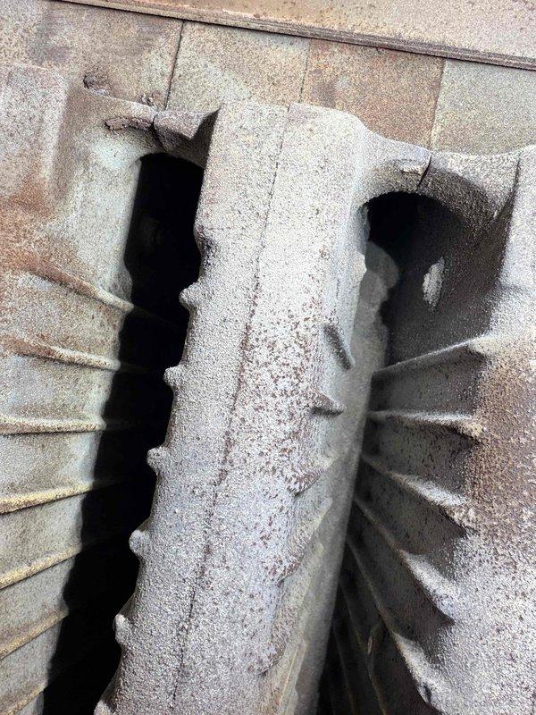 Performed routine maintenance on boiler system. Inspected heat exchanger fins, noting minor rust formation and debris accumulation. Examined concrete housing structure with particular attention to ventilation channels, which showed normal weathering but remain functionally sound.