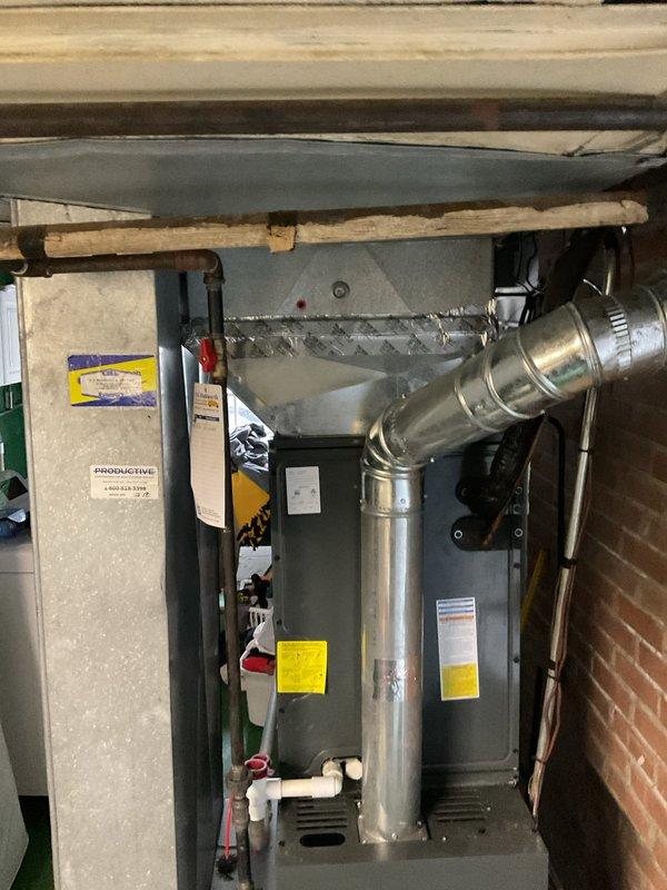 Performed annual heating maintenance on residential furnace system in basement utility area. Inspected the gas furnace unit, adjacent water heater, and connected air purification system with all associated ductwork, PVC drainage pipes, and electrical connections. System was found to be functioning properly with no issues requiring repair.