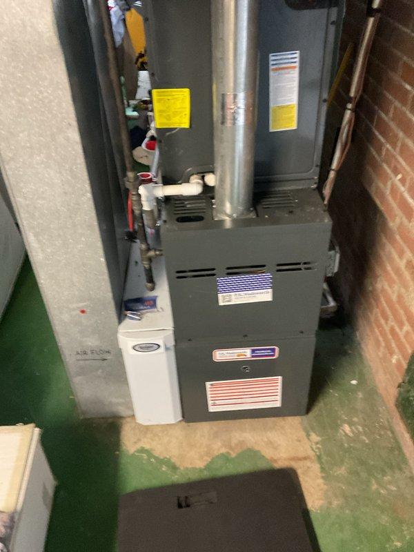 Performed annual heating maintenance on residential furnace system in basement utility area. Inspected the gas furnace unit, adjacent water heater, and connected air purification system with all associated ductwork, PVC drainage pipes, and electrical connections. System was found to be functioning properly with no issues requiring repair.