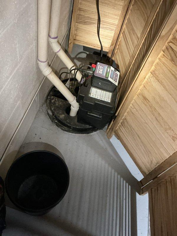# Plumbing Site Visit Summary

Conducted comprehensive mid-morning plumbing inspection of residential property. Performed thorough evaluation of basement sump pump system and bathroom shower valve installation.

## Inspection Findings

**Sump Pump System Assessment:**
Inspected residential sump pump installation located in basement utility area. Examined black-cased submersible pump unit positioned in concrete sump pit with proper drainage configuration. Verified white PVC discharge piping routing along wall with visible purple primer marks at joints indicating recent plumbing work. Confirmed electrical connection and power supply cord properly secured. Noted secondary pit opening in floor area. Evaluated pump positioning, pit depth, and overall system accessibility. Assessed surrounding concrete floor condition and checked for moisture indicators or drainage concerns.

**Shower Valve Inspection:**
Evaluated Delta brand pressure-balance shower valve with chrome finish mounted in tiled 