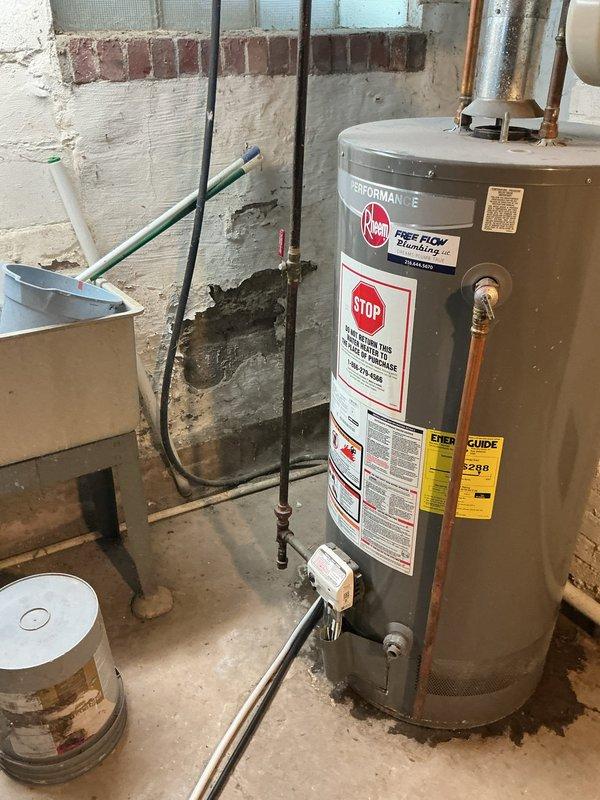 Conducted on-site evaluation of existing 50-gallon natural gas water heater (Rheem model VG5048CP1400U, manufactured April 2018, 40,000 BTU input) for replacement estimate. Unit showed signs of age with visible water staining on concrete floor and wall surfaces around base, indicating potential previous leakage or condensation issues. Documented current installation configuration including copper supply line connections, venting system, and gas line setup. Assessed clearances, accessibility, and existing plumbing infrastructure to determine replacement requirements and provide comprehensive estimate for new water heater installation.