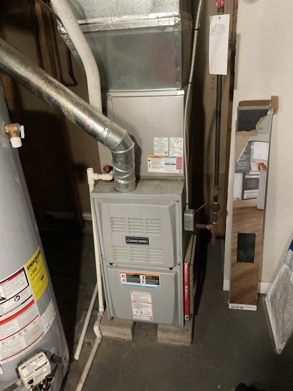 # HVAC Heating Maintenance Service Report

Performed comprehensive heating system maintenance on a Concord brand residential furnace installation. Conducted thorough inspection of the furnace unit, evaporator coil, ductwork connections, and associated HVAC components to ensure proper operation ahead of the heating season.

Inspected the evaporator coil assembly, noting accumulated dust and particulate on the finned surfaces typical of normal system operation. Examined copper refrigerant lines and brass fittings for signs of wear, corrosion, or leaks. Verified all electrical connections, including bundled wiring to the blower motor assembly, were secure and showed no signs of overheating or damage.

Assessed the condition of the metallic ductwork system, including the main trunk lines and flexible duct connections, confirming proper sealing and support. Inspected PVC condensate drain lines for proper pitch and drainage functionality. Verified furnace venting system integrity and clearan