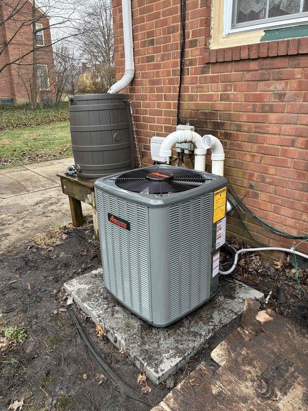 # HVAC Install - A/C Only Job Description

Completed installation of a complete residential air conditioning system consisting of an outdoor condensing unit and indoor air handler. The outdoor unit was positioned on a concrete pad adjacent to the building structure with proper clearances maintained for airflow and serviceability. Refrigerant lines were run from the exterior condenser through the building envelope and connected to the air handler located in the basement mechanical room.

The indoor air handler was mounted against the concrete block wall in the basement with appropriate structural support. Refrigerant lines were properly insulated with black foam insulation and routed vertically along the wall to minimize exposure and maintain efficiency. Supply ductwork was connected to the air handler using flexible duct connectors to reduce vibration transmission, with rigid ductwork extending from the unit and secured with metal framework and hangers.

All electrical connections were