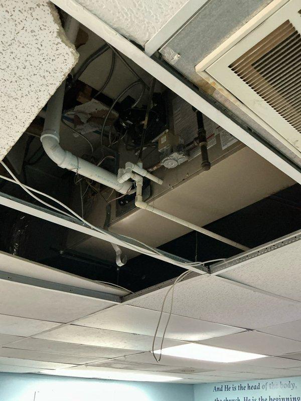Conducted site assessment for commercial ceiling-mounted heating unit replacement and air conditioning options. Accessed plenum space through drop ceiling system to evaluate existing HVAC infrastructure, including ductwork routing, electrical connections, and available clearances. Documented current equipment configuration, mechanical space conditions, and installation requirements. Photographed existing unit, ductwork connections, and attic mechanical space to develop replacement options and specifications for commercial heating and cooling system upgrade.