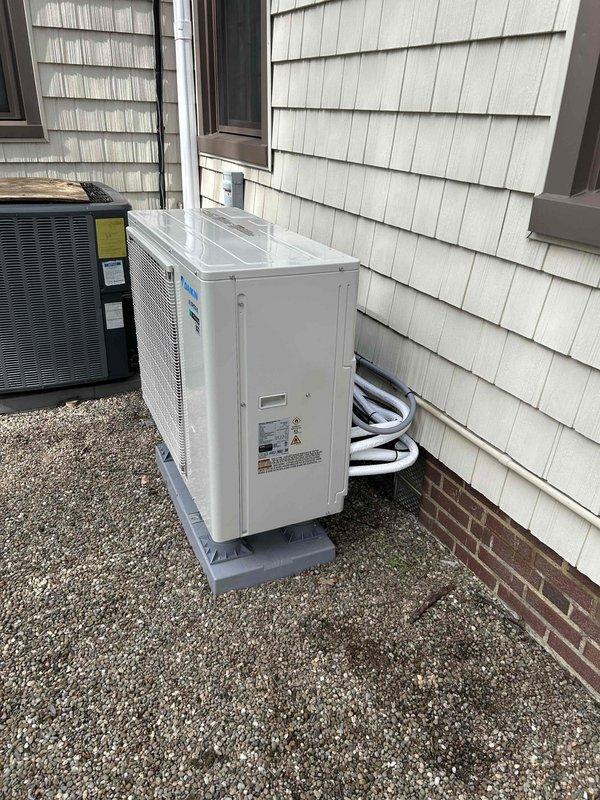 Completed installation of ductless mini-split HVAC system including outdoor heat pump unit mounted on composite pad with proper refrigerant lineset connections and indoor wall-mounted air handler with integrated controls. Installed 50-amp electrical sub-panel to support system requirements and ensured all electrical connections meet code specifications. System tested and operational with proper airflow and temperature control verified.