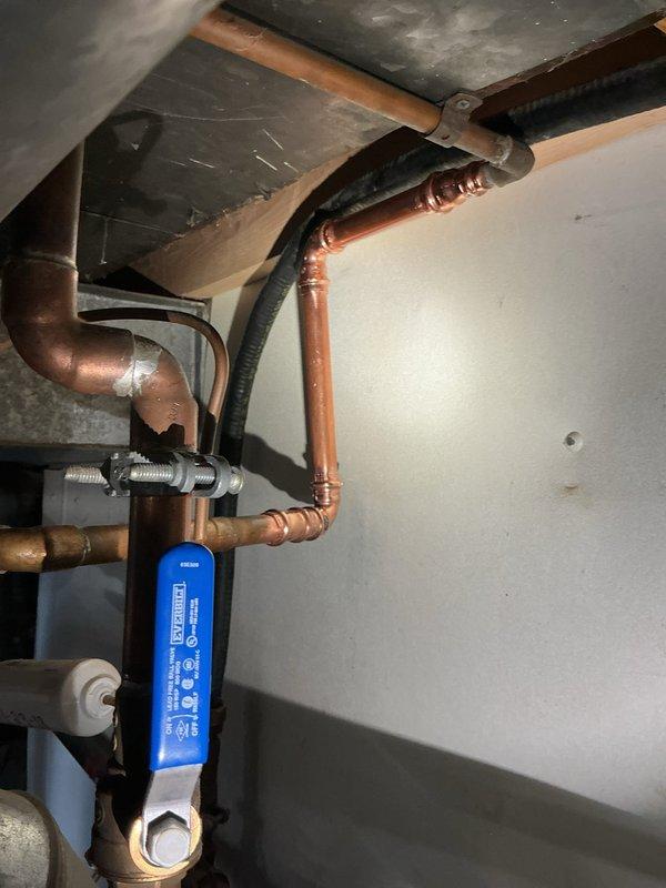 Returned to property to complete previously initiated repairs on the water heating system. Removed and replaced the failed expansion tank with a new unit, properly mounting it to the wall with secure strapping and marking it with installation date and pressure specifications. Completed copper pipe repairs on the water supply lines, installing new fittings and joints to address leaking connections. Installed a new valve in the system as indicated by labeling. All copper connections were properly soldered and tested for leaks. The expansion tank was pressurized to 60 PSI and integrated into the piping network. Verified proper operation of all components, including the water heater connections, shut-off valves, and the newly installed expansion tank. System was tested and confirmed to be functioning correctly with no active leaks upon completion.