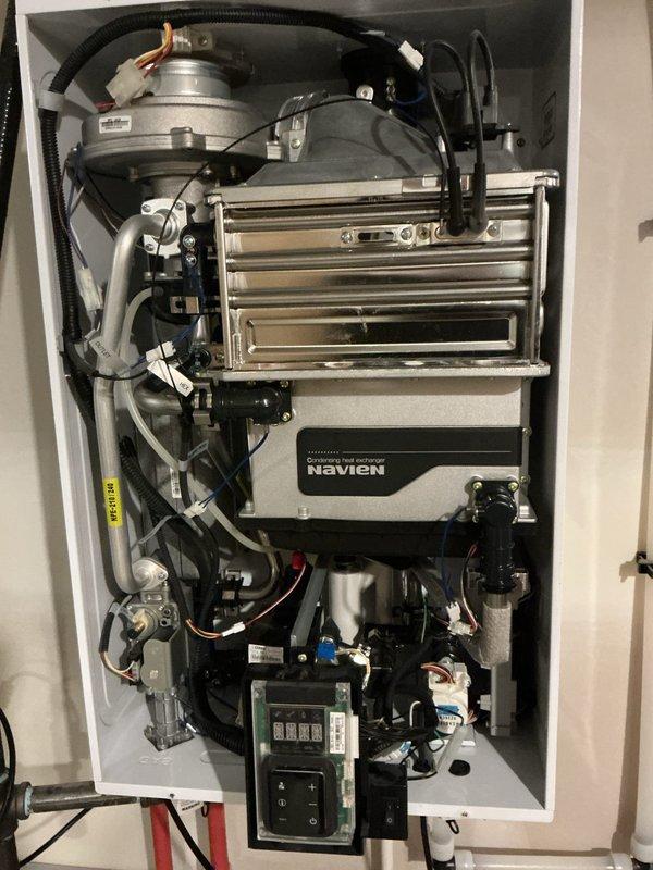 # Tankless Water Heater Maintenance Service

Performed routine maintenance on a wall-mounted Navien tankless water heater unit. Conducted complete system flush to remove mineral buildup and sediment from the heat exchanger, inspected internal components including the blower assembly and heat exchanger fins, verified proper operation of all control systems and safety devices, and confirmed optimal performance of PEX plumbing connections and gas line installations.