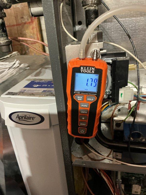 Completed routine heating maintenance inspection on residential HVAC system. Performed diagnostic testing using differential manometer to measure static pressure across air handler, recording reading of 1.79 inches water column to verify proper airflow and system performance. Inspected Aprilaire humidifier component for proper operation and integration with heating system. Verified all electrical connections, control wiring, and safety switches within unit compartment, confirming proper wire terminations and secure connections at terminal blocks. System operating within normal parameters with no deficiencies noted.