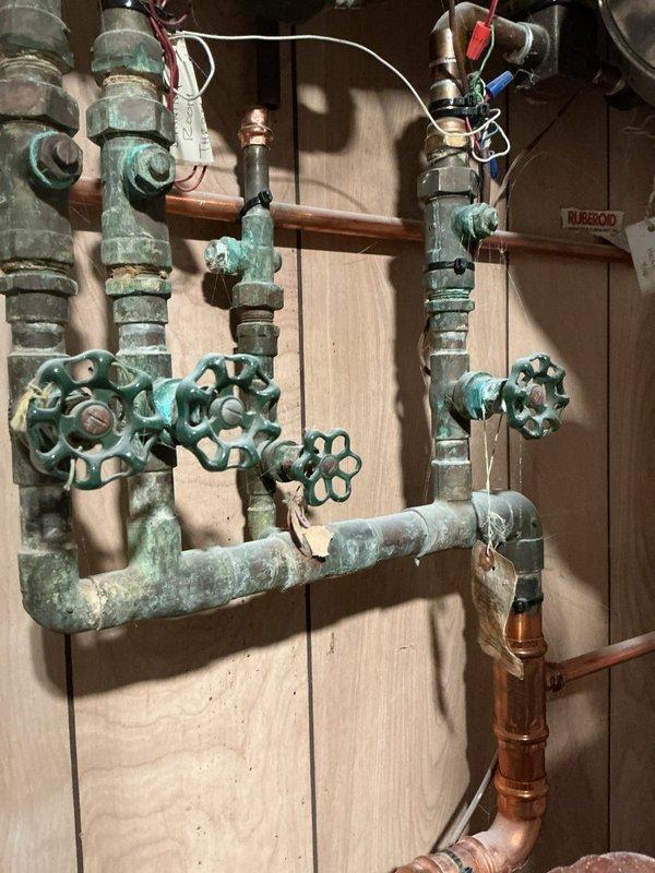 Completed comprehensive boiler maintenance inspection including visual assessment of heating system components, expansion tank, water heater, and associated piping network. Documented existing copper pipe oxidation on valve assemblies and confirmed all mechanical connections and safety controls were functioning properly.