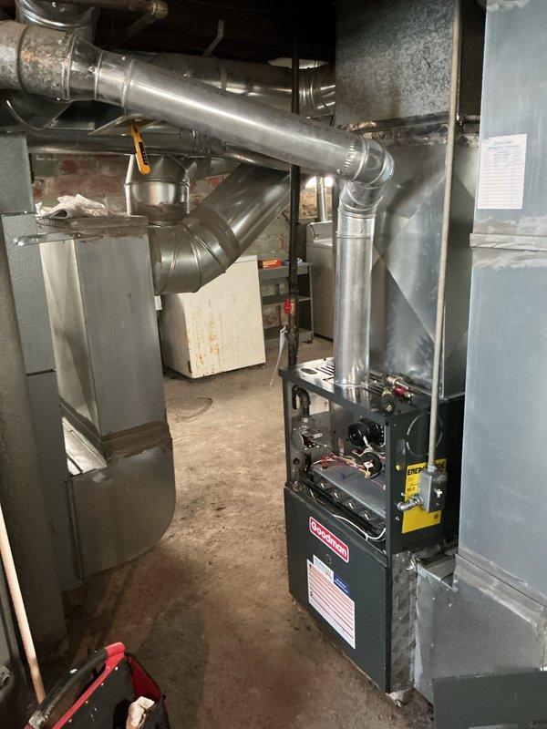 Completed scheduled heating maintenance on Goodman residential furnace system. Performed comprehensive inspection of unit operation, verified proper airflow through ductwork connections, checked all safety labels and indicators for compliance, and confirmed system functionality with illuminated control panel displaying normal operating status. All mechanical components, duct connections, and ventilation pathways were found to be in proper working order with no immediate service needs identified.