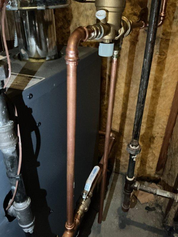 Completed first-year preventive maintenance on residential hot water boiler system. Performed comprehensive inspection of boiler unit, verified proper operation of all copper supply and return lines, tested blue-handled isolation valves for functionality, and confirmed secure mounting of all plumbing connections and brass fittings. Inspected sediment filter housing for debris accumulation, examined electrical components including junction box and circulator pump motor for proper operation, and verified all wiring connections were secure with no signs of overheating or damage.