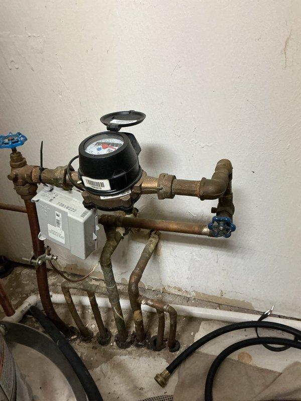 Completed first-year maintenance inspection on tankless water heater system. Performed visual assessment of all plumbing connections, copper supply lines, shut-off valves, and associated piping infrastructure. Inspected water meter assembly, valve operations, and verified proper clearances around equipment. Documented existing copper pipe oxidation and overall system condition with photographic records for maintenance history.