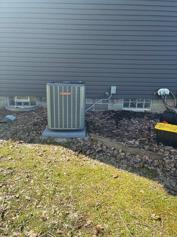 Completed full HVAC system installation including a 96% high-efficiency gas furnace and matching air conditioning condenser unit. Installed new outdoor condensing unit (Model: CMPTA0800CMAA, Serial: A8911C1076, 2024 manufacture date) on concrete pad with proper clearances from foundation and adequate airflow access. Unit positioned against home exterior with appropriate electrical disconnect box mounted to wall and proper line set routing. Verified A2L refrigerant safety compliance, confirmed 24V/60Hz electrical specifications, and ensured maximum outlet temperature rating of 200°F per manufacturer guidelines. System installation met all manufacturer specifications for minimum room area requirements and proper refrigerant charge levels. All equipment secured on stable concrete pad with proper drainage considerations and landscape protection maintained around installation area.